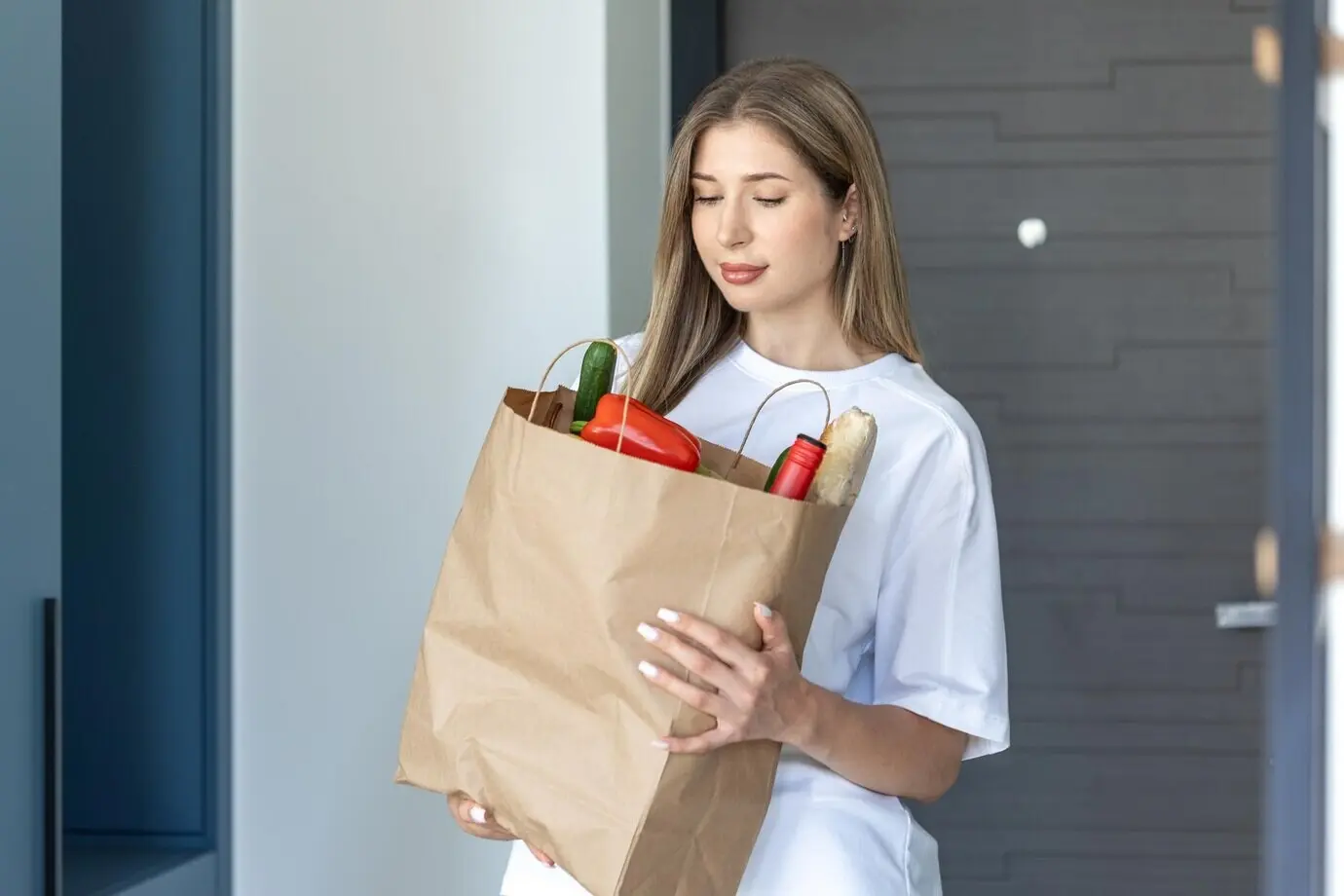 Женщина с пакетом продуктов, доставка еды на дом, свежие овощи и хлеб.